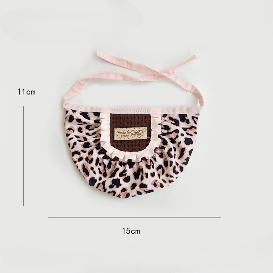 Cat wearing Mokka leopard print ruffle bib sitting on wooden floor