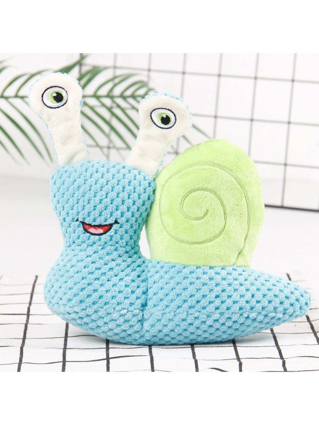 Petkin Snail Plush Dog Toy positioned to show its snail shape and colors