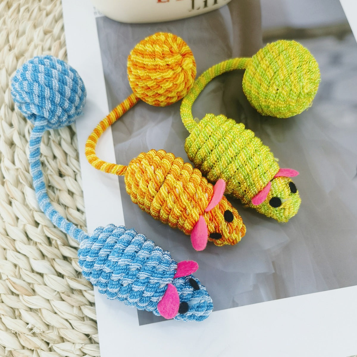 Moo Long Tail Mouse Chase cat toy next to a cat paw reaching for the toy