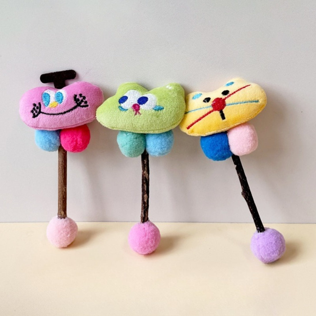 Moo plush cat toy in playful pose with stick and string visible