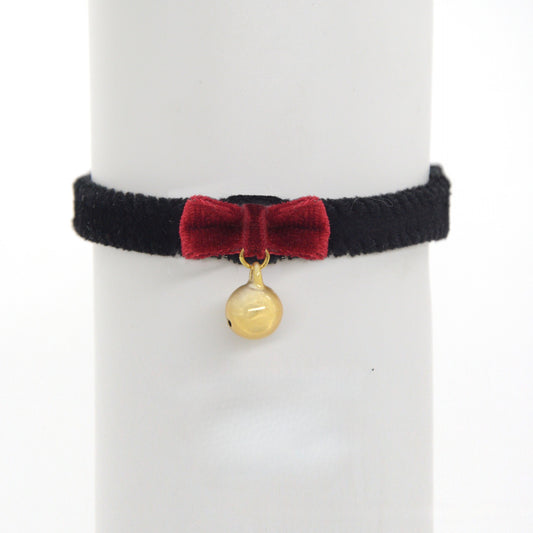 Close-up of black velvet cat collar showing adjustable strap and bell
