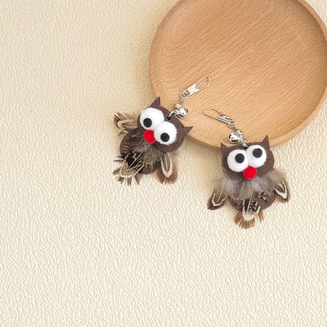 Two owl-shaped cat toy attachments displayed below a round tray