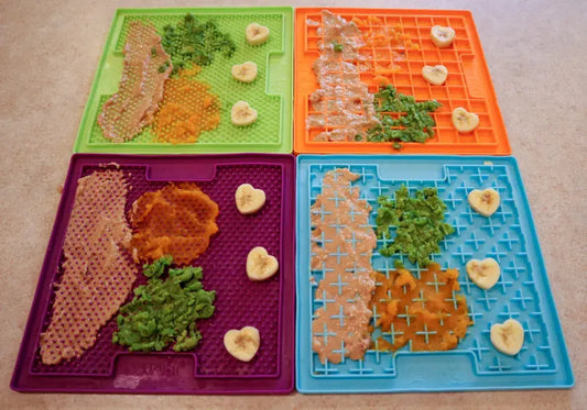 Four colorful lick mats prepared with soft food