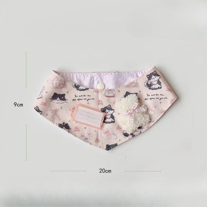 Baby wearing pink cartoon cat neck bib smiling and sitting in high chair