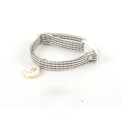 Mokka Rose Charm cat collar wrapped around a cylindrical object