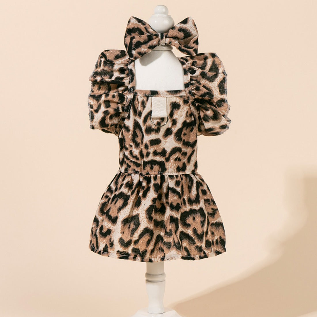 Leopard print dog dress with a large bow on the back, displayed on a white background