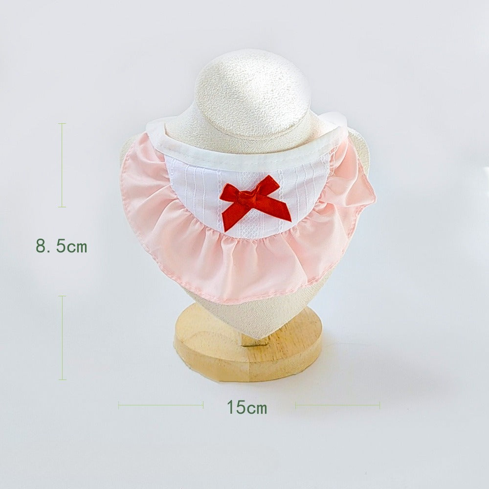Close-up of Mokka cat collar showing ruffle detail and metal bell on beige fabric