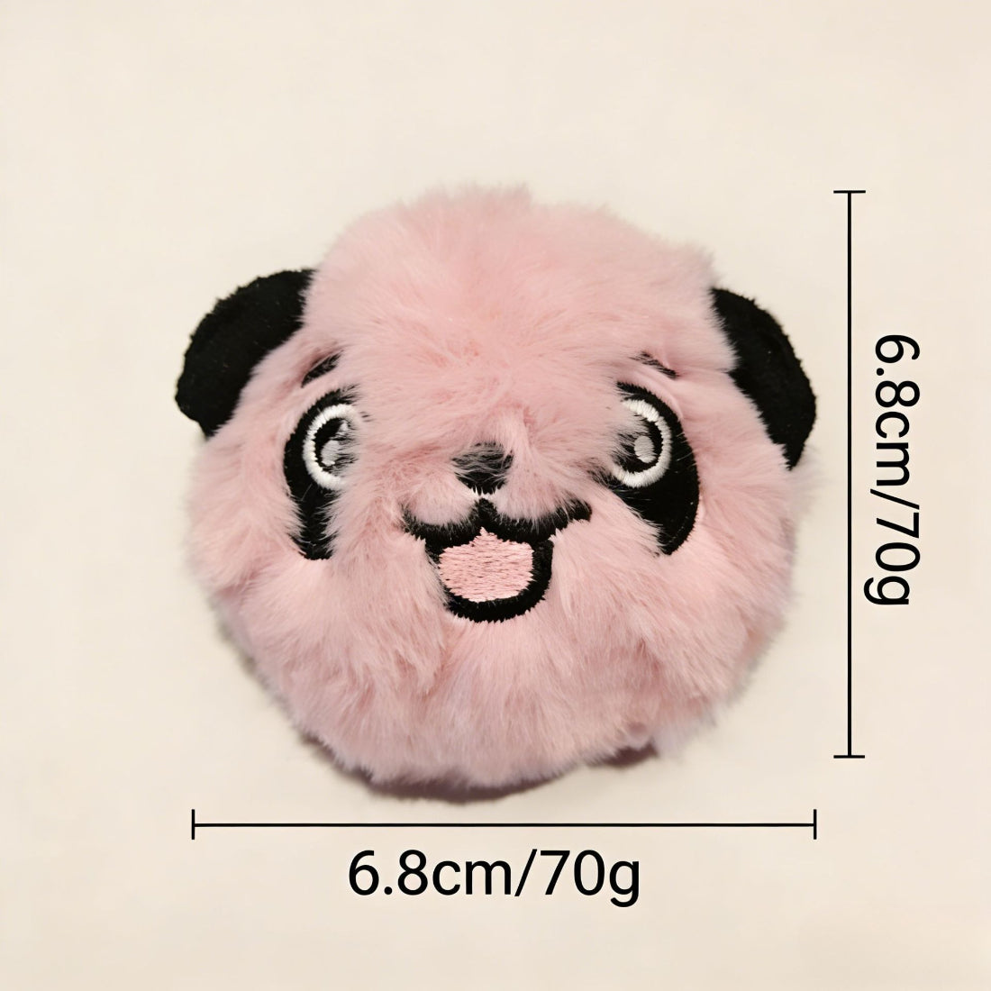 Petkin plush ball dog toy held in hand to show size and softness