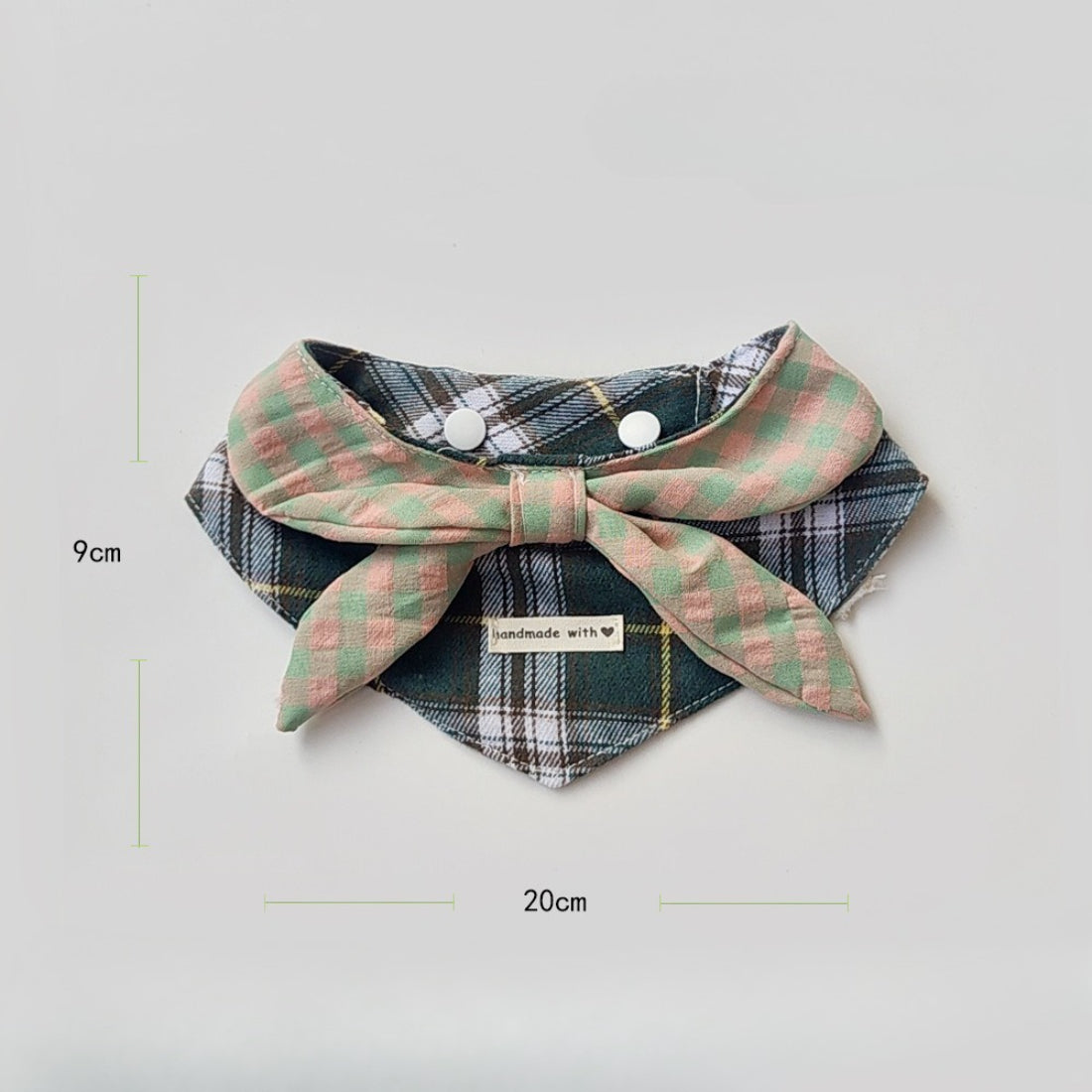 Folded Mokka layered plaid cat bib highlighting the pattern and texture