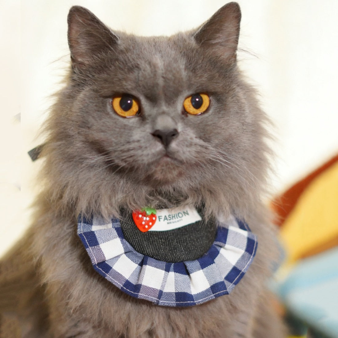 Close-up of strawberry gingham cat bib showing soft fabric and detailed stitching