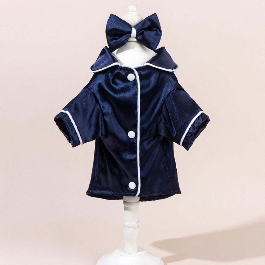 Side view of a small dog wearing a shiny satin shirt with a bow detail
