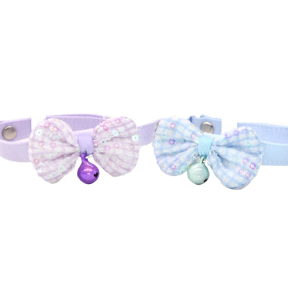 Pastel pink cat collar with a bow and small bell on a white background