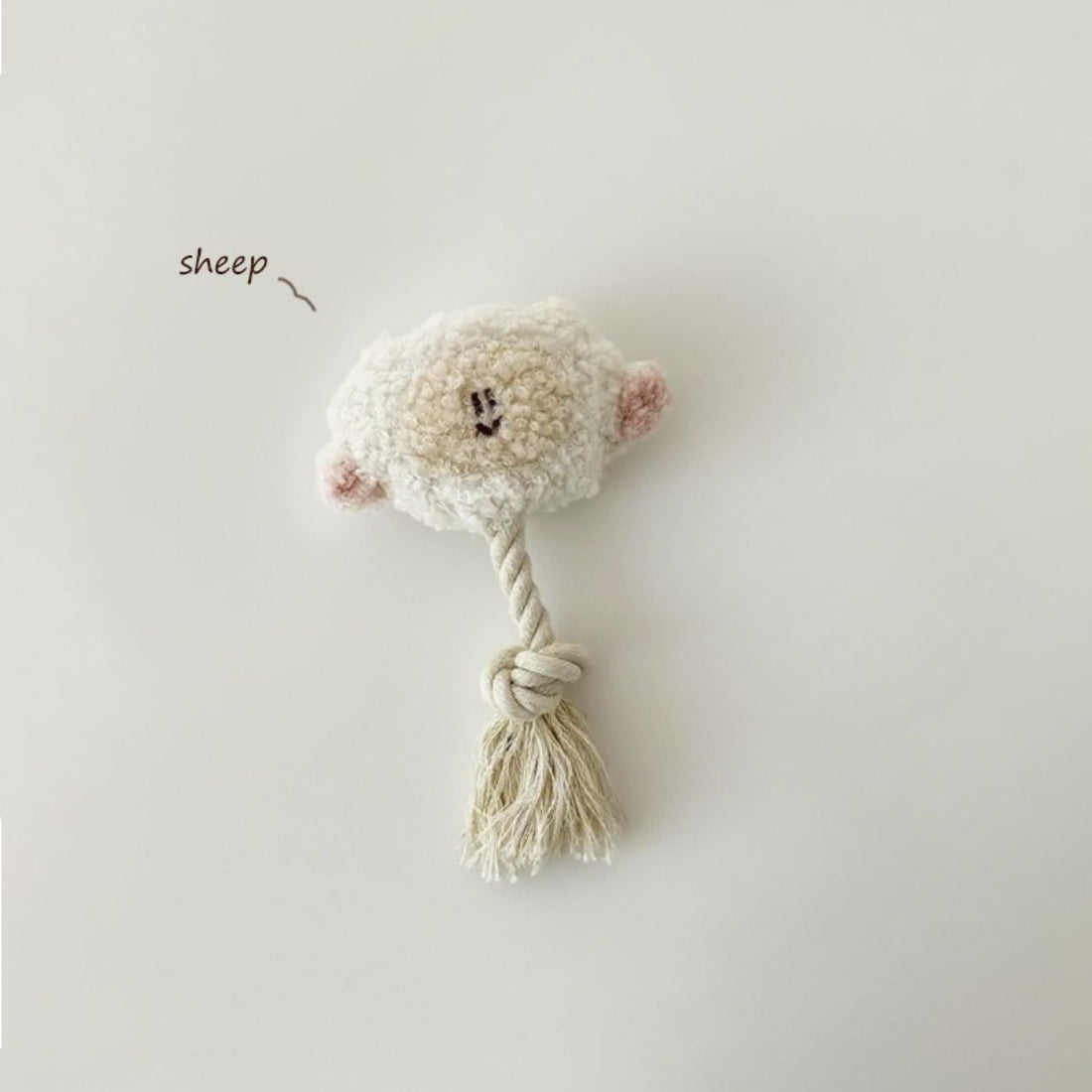 Petkin animal plush dog toy held in hand to show size and rope tail