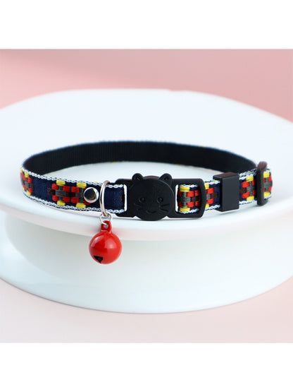 Mokka cat collar displayed next to a small bell accessory
