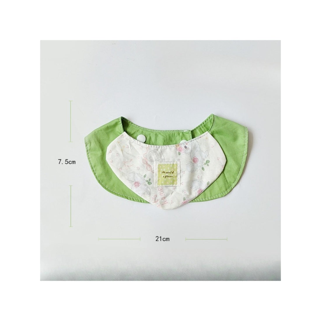 Cat wearing soft green neck bib with adjustable buckle visible