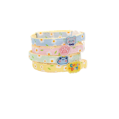 Close-up of white daisy charm attached to brown breakaway cat collar
