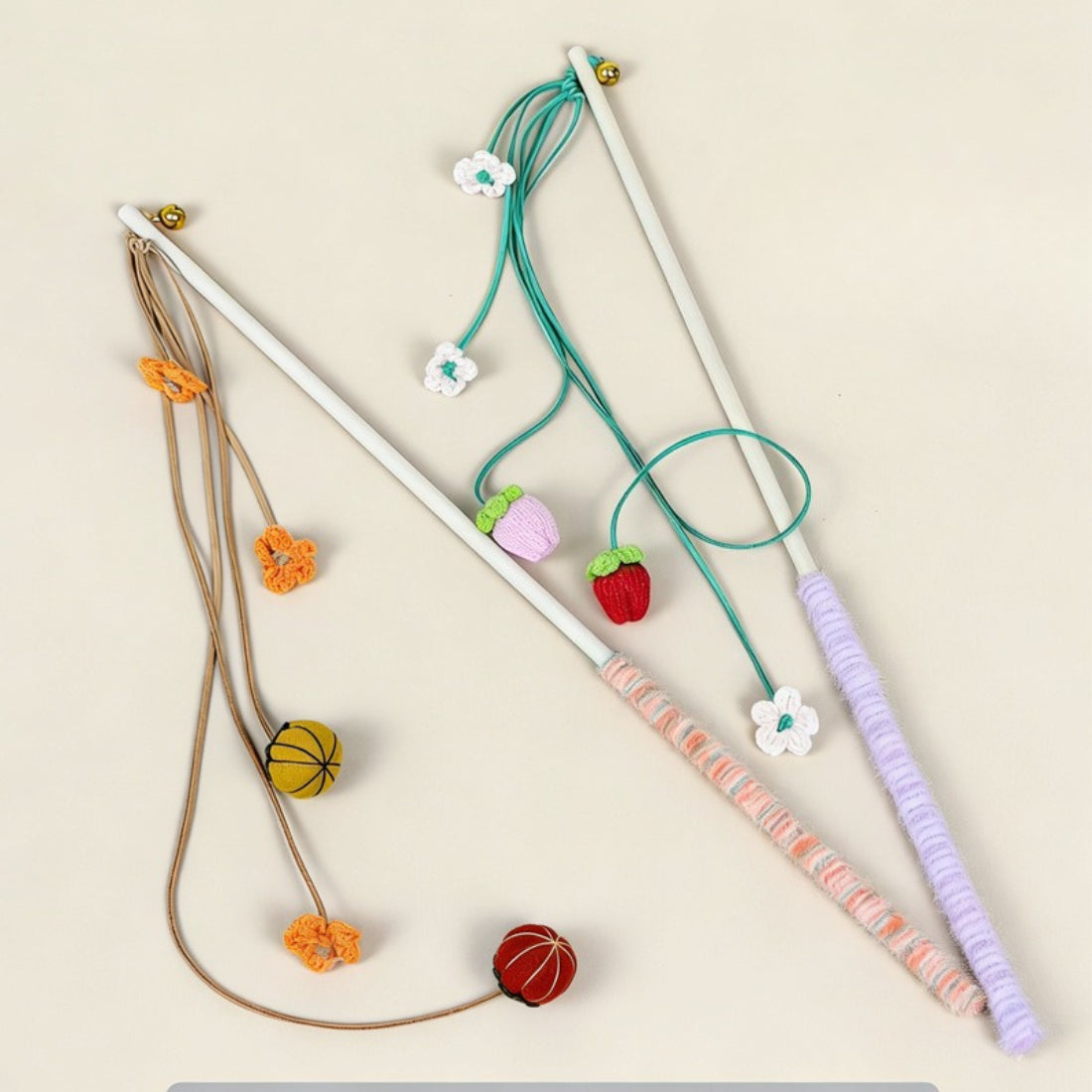 Close-up of orange pom pom teaser attached to wooden wand for cats