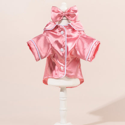 Small dog wearing a chic satin shirt with a bow, standing on a white background