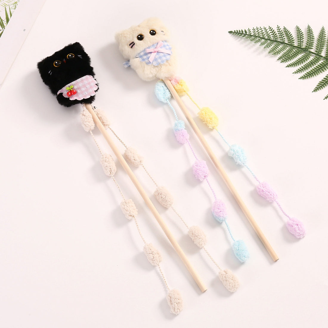 Close-up of Moo plush cat teaser wand toy showing detailed feathers and fabric textures