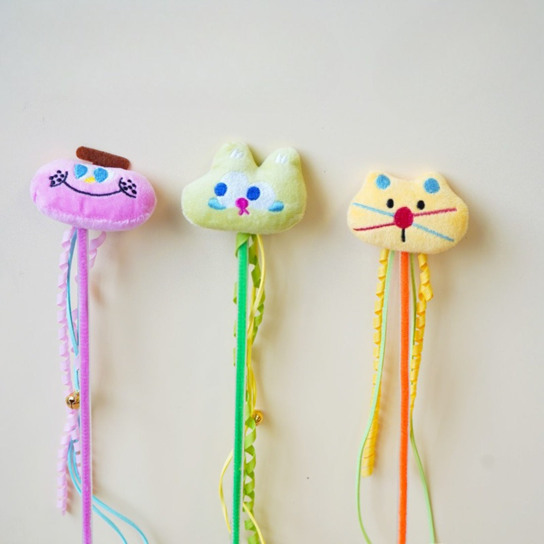 Moo plush cat teaser wand with soft fabric and colorful feathers on a wooden stick