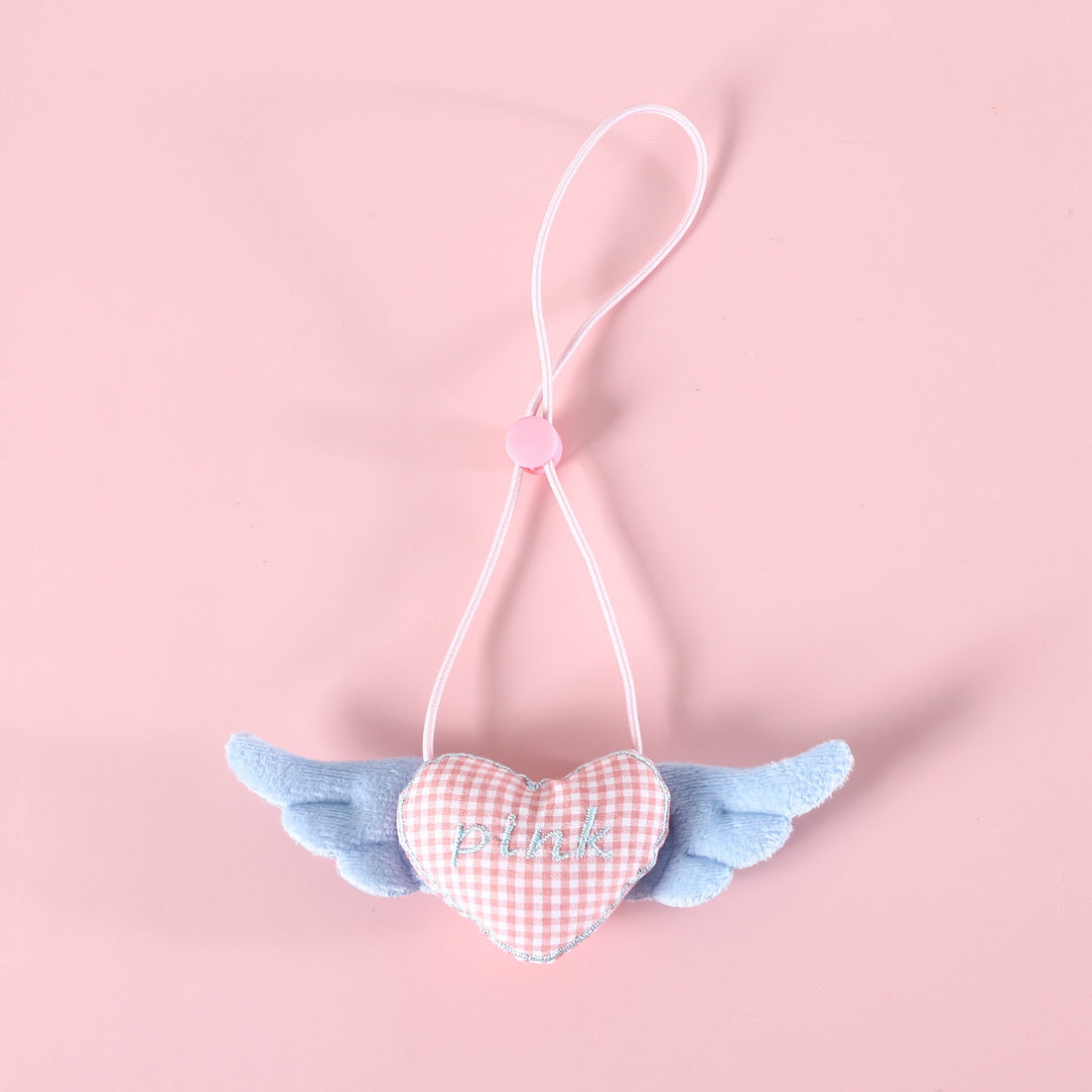 Mokka cat collar with winged heart charm laid out with charm facing forward