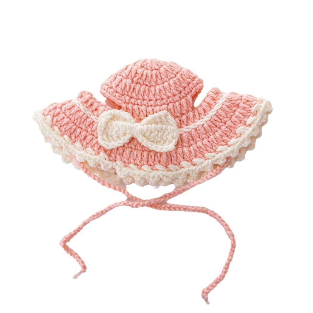Pink crochet cat hat named Ozzie displayed on a white background