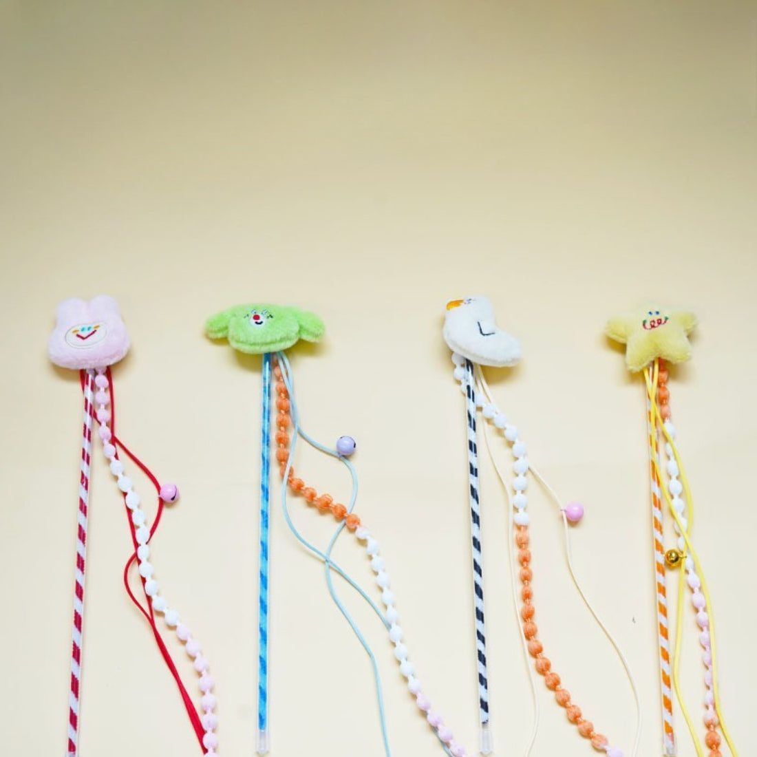Moo plush cat teaser wand with colorful beads on a white background