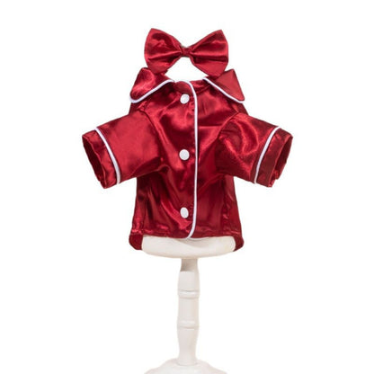 Small dog sitting while wearing a smooth satin shirt with a decorative bow