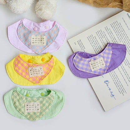 Pastel gingham cat bib with pink and white checkered pattern on a white background