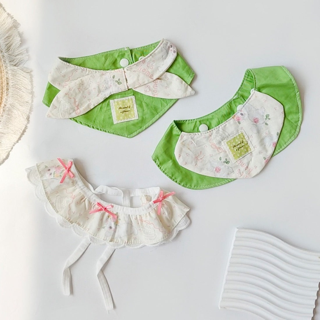 Soft green cat neck bib with adjustable strap on a white background