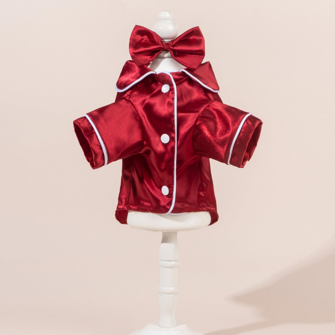 Close-up of satin dog shirt with a large bow on the back, displayed on a small dog
