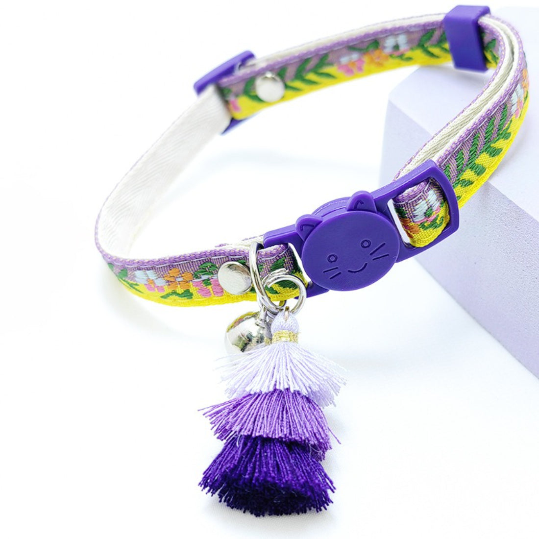 Mokka cat collar with floral design, tassel, and bell laid flat