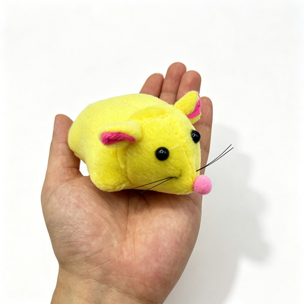 Yellow mouse cat toy resting on an open palm