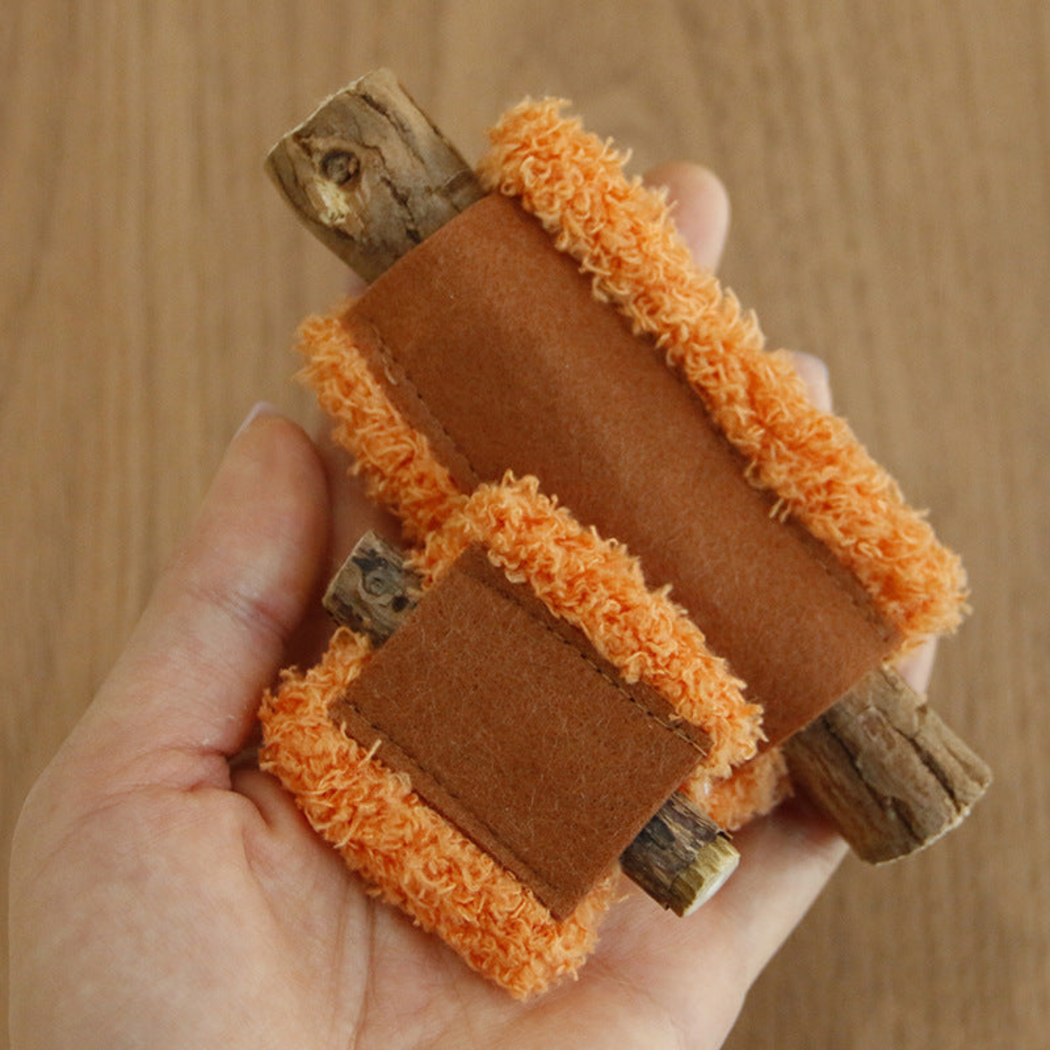 Orange cat toys with brown stitched panels and exposed sticks held in a hand
