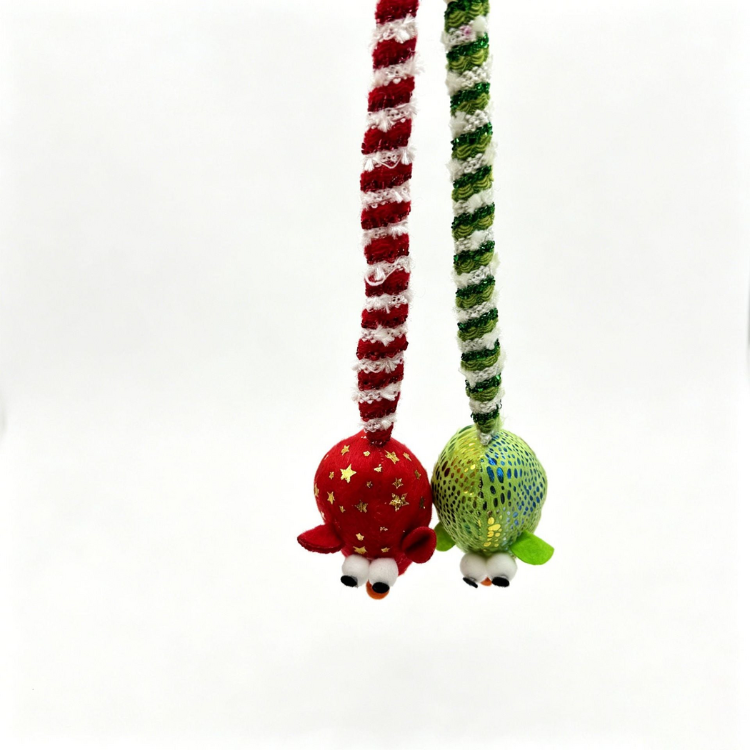 Red and Green mouse cat toys hanging nose-down, showing their backs and striped tail attachments