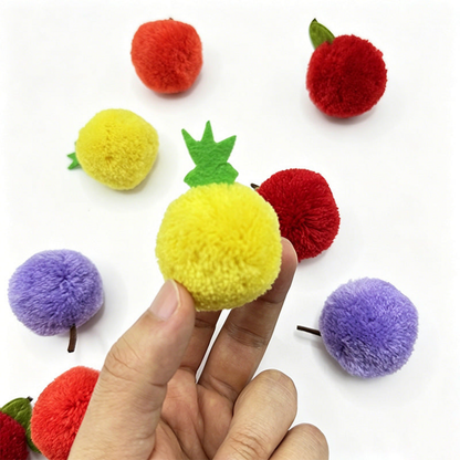 Hand holding a yellow Pineapple ball cat toy with its green leafy top visible