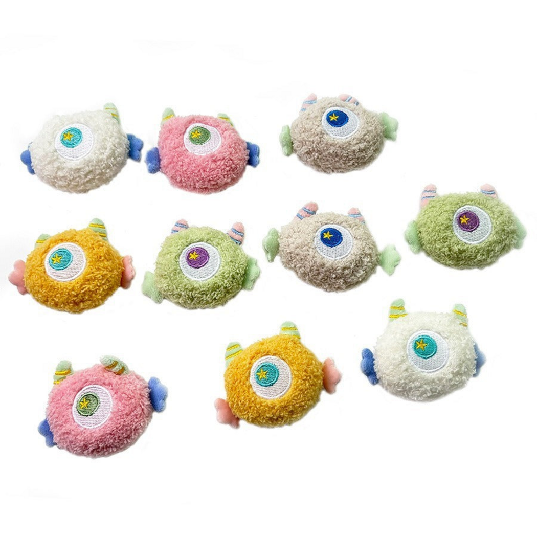 Green, Pink, Yellow, Beige and White one-eyed cat toys displayed together