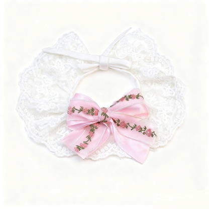 Pink Pet Neckwear spread flat with a floral bow, white tie straps and scalloped lace-look edge