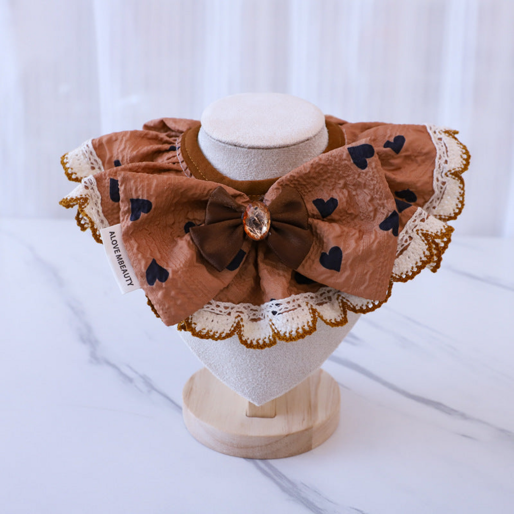Hearts Pet Neckwear with a dark brown bow and scalloped white edging, front view on a stand