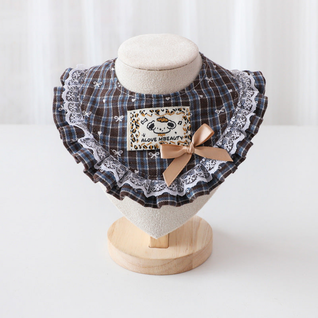 Brown plaid Pet Neckwear with a beige bow, cartoon patch and white lace-look edging, front view on a stand