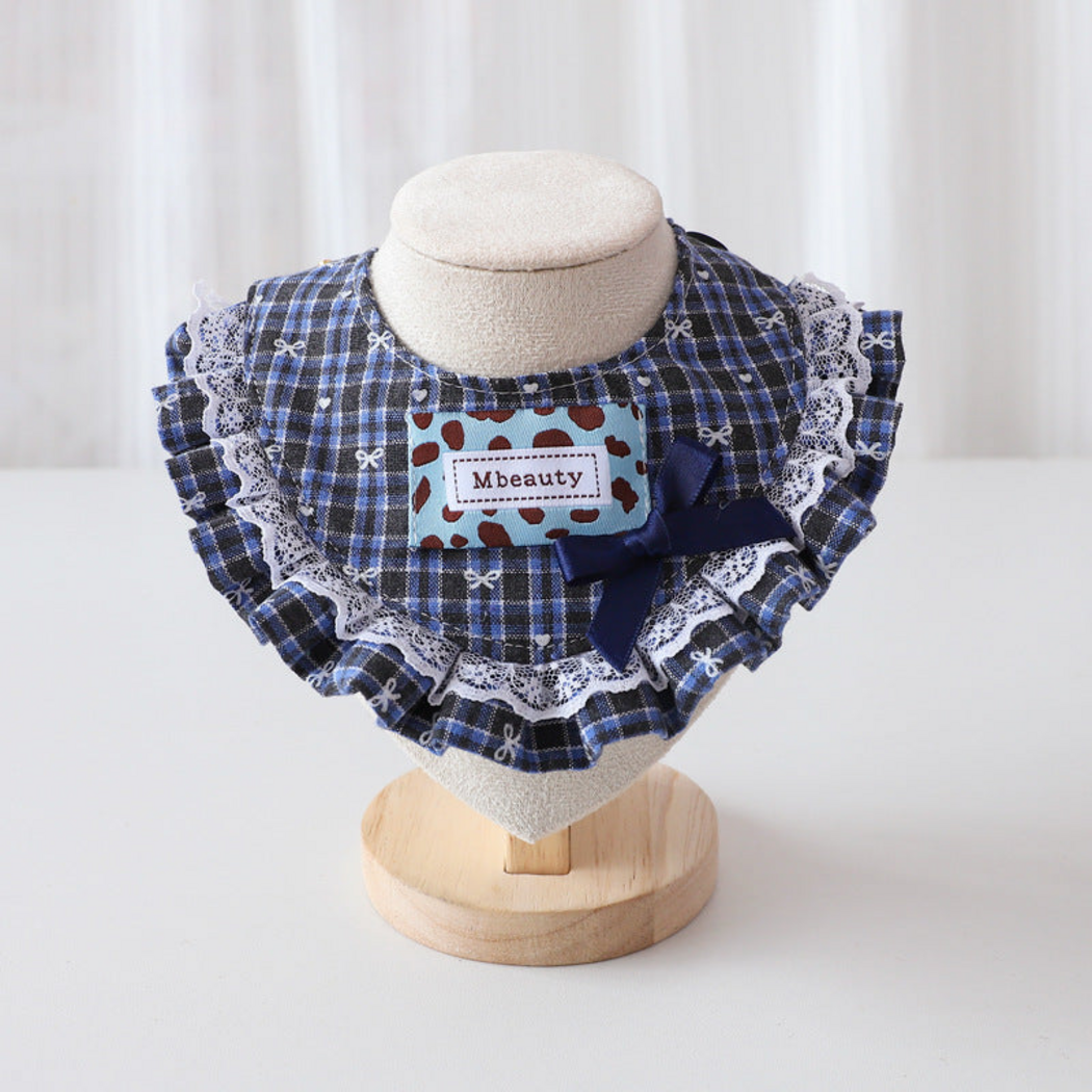 Blue plaid Pet Neckwear with a navy bow, rectangular patch and white lace-look edging, front view on a stand