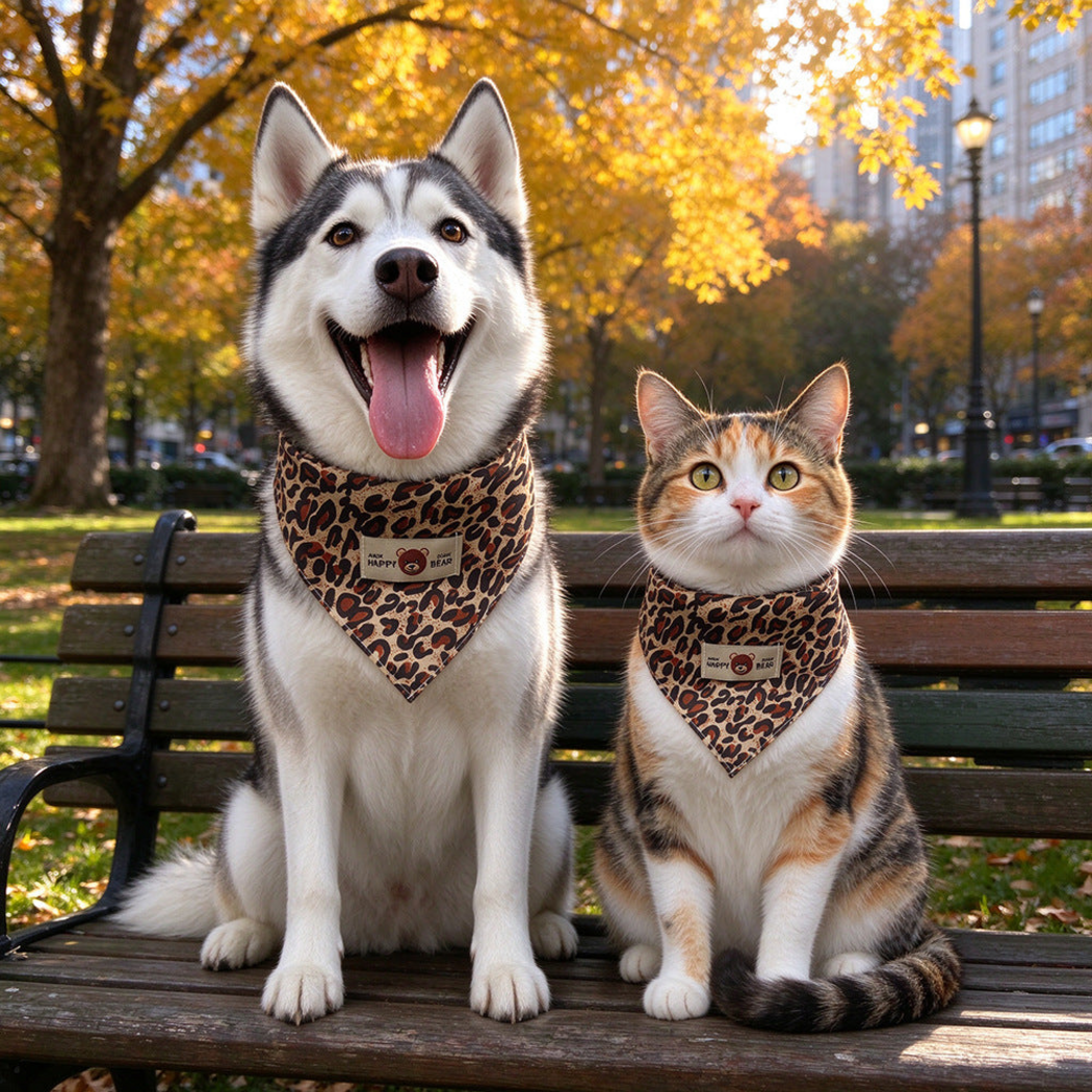 Brown leopard-print triangular pet neckwear worn by a dog and cat on a park bench