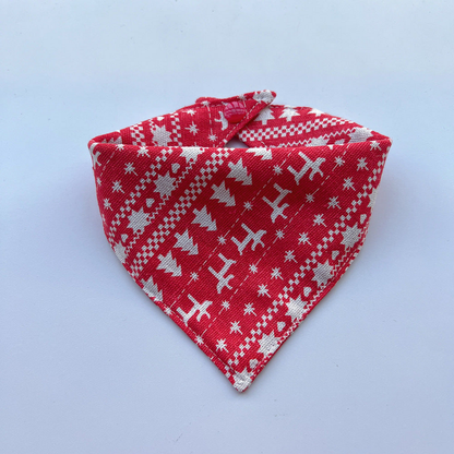 Red Bandana pet neckwear with white reindeer, trees and geometric bands, shown fastened