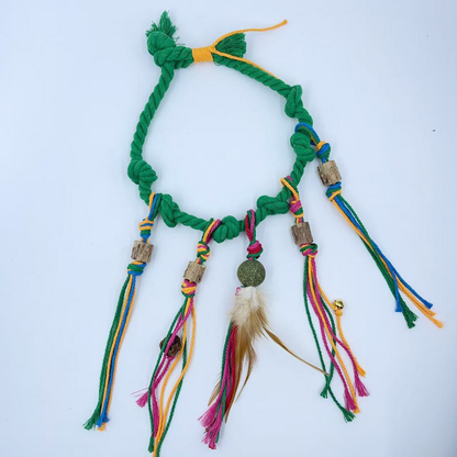 Green knotted rope cat toy laid flat with multicolored dangling cords