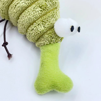 Close-up of the Mosquito cat toy's green snout, white eyes and knotted cord leg