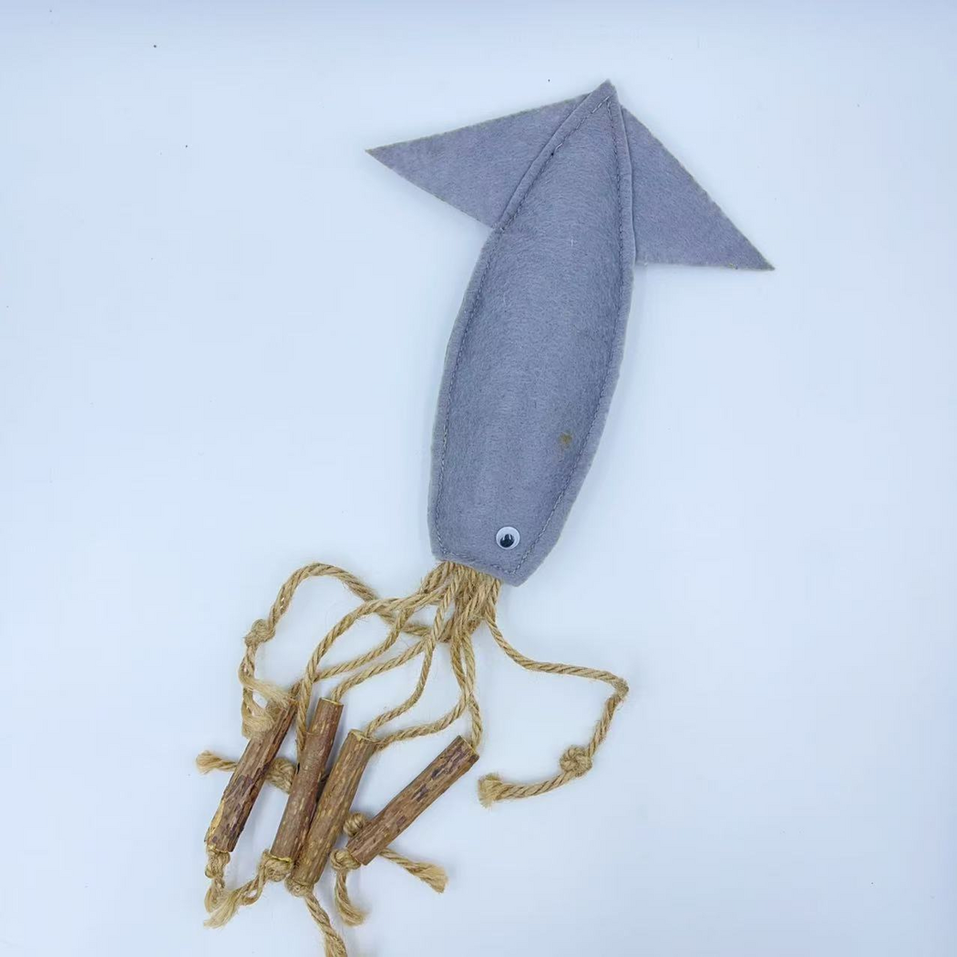 Fish cat toy arranged vertically with dangling tan cords and brown sticks