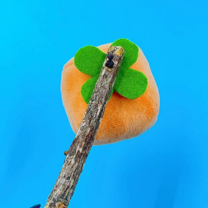 Persimmon cat toy, front detail showing the green four-lobed top and bark-textured stick