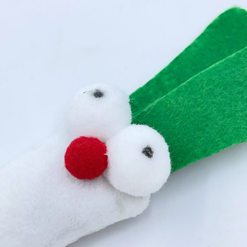 Close-up of the scallion-shaped cat toy's round eyes, red nose and overlapping green leaves