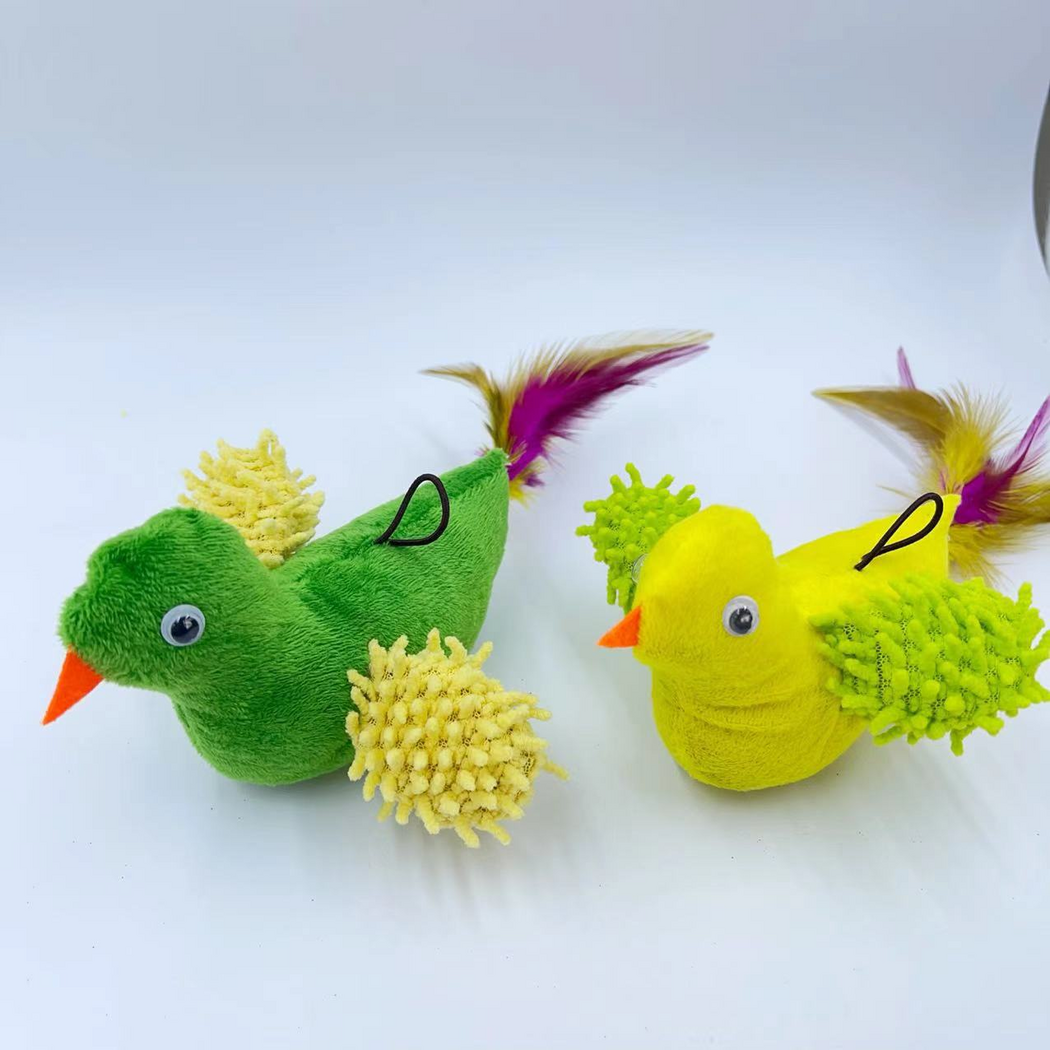 Green and Yellow bird-shaped cat toys showing round eyes, orange beaks and textured wing patches in close-up