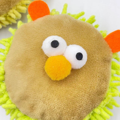 Close-up of the Green lion-face cat toy with raised eyes, orange ears and a yellow nose